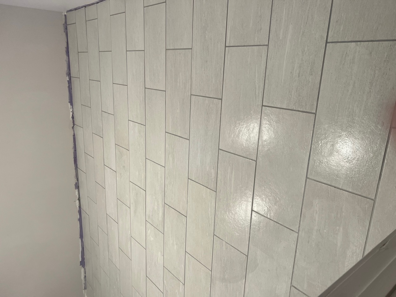 New tile wall, grouted and wiped clean.